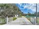 Long driveway leading to home with gated entrance and tennis court at 1931 Bayshore Dr, Englewood, FL 34223