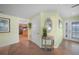 Bright entryway with a decorative table, view into the kitchen, and a glass door at 1931 Bayshore Dr, Englewood, FL 34223