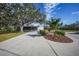 Landscaped front yard with circular driveway, mature trees, and gazebo at 1931 Bayshore Dr, Englewood, FL 34223