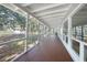 Long, covered screened porch with wood flooring and views of the backyard at 1931 Bayshore Dr, Englewood, FL 34223