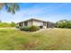 House exterior showcasing landscaping and a screened enclosure at 22561 Blanchard Ave, Port Charlotte, FL 33952