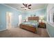 Spacious main bedroom with light blue walls, ceiling fan, and walk-in closet at 2427 Daisy Dr, North Port, FL 34289