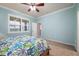 Bedroom with a queen bed, light blue walls and plantation shutters at 2427 Daisy Dr, North Port, FL 34289