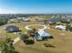 Aerial view of a luxury community with houses, a lake, and ocean views at 24490 Wallaby Ln, Punta Gorda, FL 33955