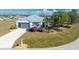 Single-story home with gray metal roof, attached garage, and landscaped yard with pool at 24490 Wallaby Ln, Punta Gorda, FL 33955