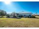 House back view, showcasing a screened enclosure and a spacious backyard at 24490 Wallaby Ln, Punta Gorda, FL 33955