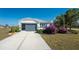 Charming single-story home with a gray garage door and lush landscaping at 24490 Wallaby Ln, Punta Gorda, FL 33955