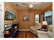 Bright home office with wood flooring, featuring a comfortable chair and large window at 2542 Oswego Dr, North Port, FL 34289