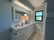 Bright bathroom with dual sinks, granite countertops, and large mirror at 3202 Meadow Run Dr, Venice, FL 34293