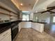 Bright kitchen with black countertops, white cabinets, open shelves and stainless steel appliances at 3202 Meadow Run Dr, Venice, FL 34293