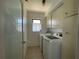 Bright laundry room with washer, dryer, overhead cabinets, and a small window at 3202 Meadow Run Dr, Venice, FL 34293