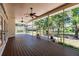 Relaxing screened porch with wood decking, ceiling fans, and backyard views at 3800 Acline Rd, Punta Gorda, FL 33950