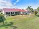 Spacious backyard with a large screened-in lanai and lush lawn with mature landscaping at 3818 Bordeaux Dr, Punta Gorda, FL 33950