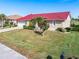 Charming home featuring a red roof, manicured landscaping, and a spacious front yard at 3818 Bordeaux Dr, Punta Gorda, FL 33950