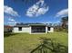 Expansive backyard view showcases the screened porch and well-maintained lawn at 5587 E Price Blvd, North Port, FL 34288