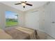 Bedroom with a ceiling fan, closet, and view of the green backyard at 5587 E Price Blvd, North Port, FL 34288