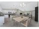 Open kitchen and dining area with stainless appliances, island seating, and modern lighting at 5587 E Price Blvd, North Port, FL 34288