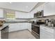 Modern kitchen features stainless steel appliances, white cabinets and granite countertops at 5587 E Price Blvd, North Port, FL 34288