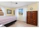 Bedroom with yellow walls, striped bedding, and a large dresser at 817 E 6Th St, Englewood, FL 34223