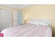 Bedroom with yellow walls and striped bedding, and a white dresser at 817 E 6Th St, Englewood, FL 34223