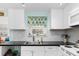 White kitchen with a window featuring stained glass and black countertops at 817 E 6Th St, Englewood, FL 34223