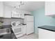 White kitchen with black countertops and stainless steel appliances at 817 E 6Th St, Englewood, FL 34223