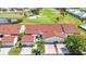 An aerial view of townhomes with attached garages, manicured lawns, and mature trees near a golf course at 1640 Atares Dr # 6, Punta Gorda, FL 33950