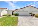 Charming exterior of the home featuring a two-car garage, green lawn and well maintained landscape at 1640 Atares Dr # 6, Punta Gorda, FL 33950