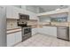 Bright kitchen featuring white cabinets, stainless steel appliances, and tile flooring at 1640 Atares Dr # 6, Punta Gorda, FL 33950