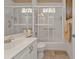 Updated bathroom with walk-in shower, grab bars, and white vanity at 2163 Silver Palm Rd, North Port, FL 34288