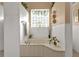 Relaxing bathroom with soaking tub, tile flooring, and a large window at 2163 Silver Palm Rd, North Port, FL 34288