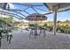 Relaxing pool area with covered patio, seating, and lush landscaping at 2163 Silver Palm Rd, North Port, FL 34288