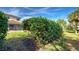 Landscaped backyard with a large hedge and grassy area at 4261 River Bank Way, Punta Gorda, FL 33980