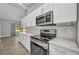 Close-up of a well-equipped kitchen featuring stainless steel appliances and bright white cabinets at 3112 Magnolia Way, Punta Gorda, FL 33950