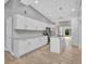 Well-lit kitchen boasts white cabinetry, stainless appliances, a kitchen island, and vaulted ceilings at 3112 Magnolia Way, Punta Gorda, FL 33950