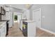 Modern white kitchen with island, stainless steel appliances, bright lighting, and access to outdoor space at 3112 Magnolia Way, Punta Gorda, FL 33950