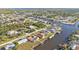 Aerial view featuring waterfront houses with boat docks along winding canals in a lush, green neighborhood at 4107 Rock Creek Dr, Port Charlotte, FL 33948