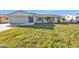 Well-maintained home with a gray front door, and a two-car garage, and gray stone pathway at 4107 Rock Creek Dr, Port Charlotte, FL 33948