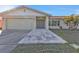 Well-maintained home with a gray front door, and a two-car garage, and gray stone pathway at 4107 Rock Creek Dr, Port Charlotte, FL 33948