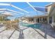 Screened-in pool with a patio table, lounge chairs, and ample seating on a sunny day at 4107 Rock Creek Dr, Port Charlotte, FL 33948