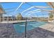 A screened-in pool features a tile border and paver surround with waterfront view and clear blue sky at 4107 Rock Creek Dr, Port Charlotte, FL 33948