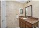 Bathroom features tiled walls, granite vanity, framed mirror, and tiled floor at 109 Peckham Se St, Port Charlotte, FL 33952