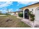 Charming home featuring an arched entryway with stone accents and well-maintained landscaping at 109 Peckham Se St, Port Charlotte, FL 33952