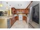 Well-lit kitchen with wood cabinetry, granite counters, and stainless steel refrigerator at 109 Peckham Se St, Port Charlotte, FL 33952