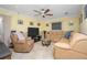 Comfortable living room featuring a large sofa, ceiling fan, and tile flooring at 109 Peckham Se St, Port Charlotte, FL 33952