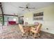 Covered patio has an outdoor dining set, swing set, and ceiling fans at 109 Peckham Se St, Port Charlotte, FL 33952