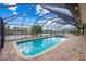 Screened-in pool with a brick patio and bright blue water, perfect for enjoying the outdoors and water views at 109 Peckham Se St, Port Charlotte, FL 33952