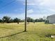 Expansive backyard with lush green grass and mature trees, perfect for outdoor activities and relaxation at 12143 Du Barry Ave, Port Charlotte, FL 33981