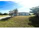 Inviting single-story home with a well-manicured lawn, mature trees, and light-colored exterior at 12143 Du Barry Ave, Port Charlotte, FL 33981