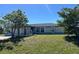Charming single-story home featuring a well-maintained lawn, mature trees, and a light gray exterior at 12143 Du Barry Ave, Port Charlotte, FL 33981